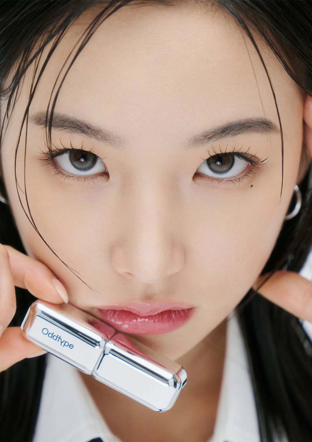 Close-up of a person holding a silver cylindrical product with 'Oddtype' branding.